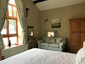 ein Schlafzimmer mit einem Bett, einem Stuhl und einem Fenster in der Unterkunft The Barn at Walker Ground Manor in Hawkshead