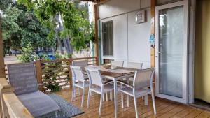 a wooden table and chairs on a deck at Mobile Home BelDesiderio Soline in Biograd na Moru