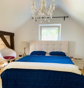 a bedroom with a blue and white bed with a chandelier at Apartment amidst nature-Riverdale, north of Munich in Fahrenzhausen