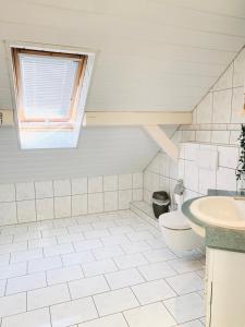 a bathroom with a sink and a toilet and a window at Apartment amidst nature-Riverdale, north of Munich in Fahrenzhausen