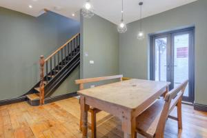 Inviting 4BD with Private Patio - Bethnal Green في لندن: غرفة طعام مع طاولة خشبية ودرج