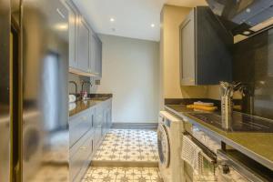 a kitchen with a sink and a washer and dryer at Inviting 4BD with Private Patio - Bethnal Green in London