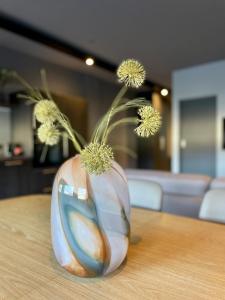 een vaas met bloemen erin zittend op een tafel bij Modern apartment with hot tub in Akureyri in Akureyri