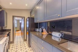 a kitchen with blue cabinets and a counter top at Inviting 4BD with Private Patio - Bethnal Green in London