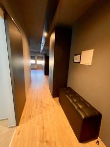 a long hallway with a leather couch in a building at Modern apartment with hot tub in Akureyri in Akureyri