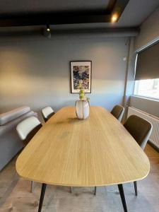 - une salle à manger avec une table et des chaises en bois dans l'établissement Modern apartment with hot tub in Akureyri, à Akureyri