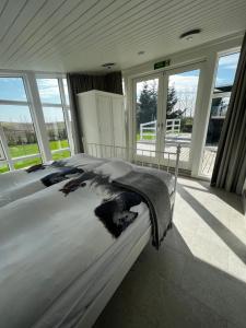 a large bed in a room with large windows at Jóhönnu Hús in Hella