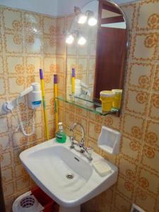 a bathroom with a sink and a mirror at Eleni's Apartments & Studios 1 in Achílleion