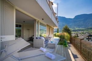 a balcony of a house with a bench and mountains at Landhaus Antonius in Appiano sulla Strada del Vino