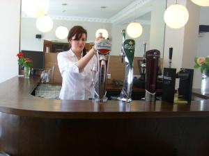 a woman standing at a counter in a bar at Phoenix Park Hotel in Dublin
