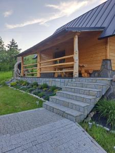 a house with a staircase leading up to a cabin at Domek Pod Tylką in Grywałd