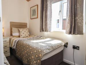 a small bedroom with a bed and a window at Doormouse Lodge in Carnforth