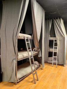Hostal Siesta & Go في مدريد: سريرين بطابقين في غرفة مع أرضيات خشبية