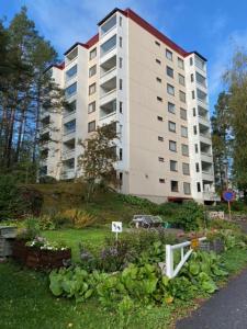 un gran edificio blanco con un jardín delante de él en Spacious 68m2 apartment with fabulous forest view en Järvenpää