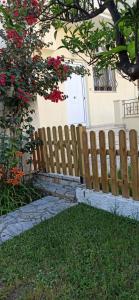 une clôture en bois devant une maison dans l'établissement marianthi's apartment, à Plataria