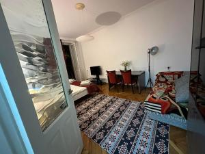 Habitación con sala de estar con mesa y puerta. en Cozy home office in Vake en Tiflis