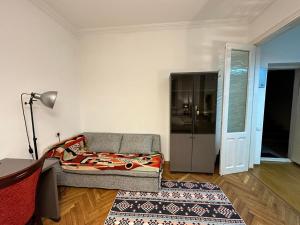 sala de estar con cama y lámpara en Cozy home office in Vake en Tiflis