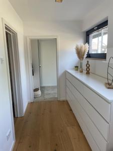 a kitchen with white cabinets and a hard wood floor at Mit gutem Gefühl ferienwohnen 