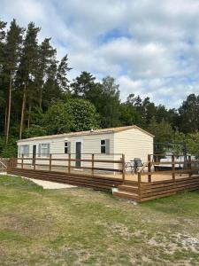 a mobile home with a deck and a trailer at Vagunmaja Apartment in Haapsalu