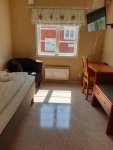 a room with a bed and a desk and a window at Turistgården Töcksfors in Töcksfors