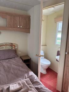 a small bathroom with a bed and a toilet at Vagunmaja Apartment in Haapsalu
