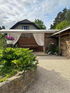 une maison avec une terrasse couverte dotée d'un rideau blanc. dans l'établissement Vagunmaja Apartment, à Haapsalu