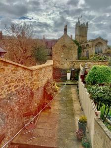 an old building with a stone wall and a courtyard at Comfy 3BD Home with Patio in Peaceful Ilminster in Ilminster