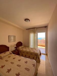 pokój hotelowy z dwoma łóżkami i balkonem w obiekcie Playa de Oro con Parking w mieście Calpe