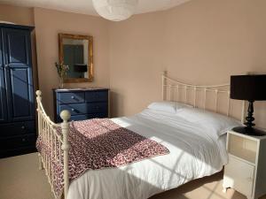 1 dormitorio con cama, tocador y espejo en Comfy 3BD Home with Patio in Peaceful Ilminster en Ilminster