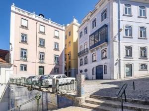 un groupe de bâtiments avec des voitures garées dans une rue dans l'établissement Classy 2BR in Principe Real w/ Heating, à Lisbonne