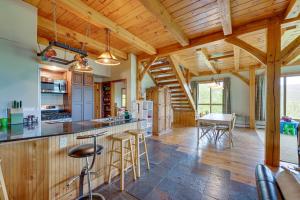 a kitchen with wooden ceilings and a bar with stools at Enchanting Dorset Mountain Home with Stunning Views! in Dorset