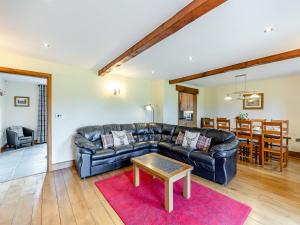 a living room with a leather couch and a table at Warth Barn - Uk44211 in Ingleton