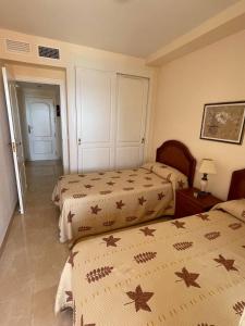 sypialnia z 2 łóżkami i drzwiami do innego pokoju w obiekcie Playa de Oro con Parking w mieście Calpe +9 zdjęć