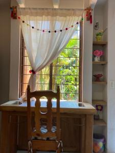 una mesa con una silla frente a una ventana en Cálida habitación a 10 min de Santo Domingo en Oaxaca de Juárez