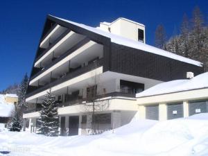 ein großes weißes Gebäude mit Schnee davor in der Unterkunft Appartement Hardenack in Innerkrems