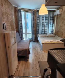 um pequeno quarto com uma cama e um frigorífico em Colonel apartment 963 em Sófia