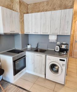uma cozinha com uma máquina de lavar roupa e um lavatório em Colonel apartment 963 em Sófia