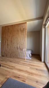 een slaapkamer met een bed en een houten vloer bij Karmelowy Apartment in Zator