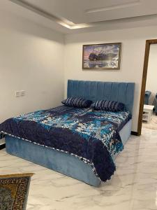 un letto blu con cuscini in una stanza di The Family Den a Rawalpindi
