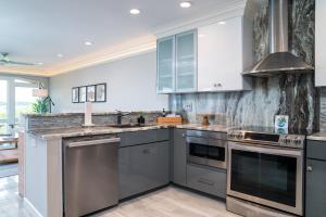 a kitchen with white cabinets and stainless steel appliances at 2105 Bay Pointe Villa in Seabrook Island
