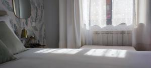 1 dormitorio con cama blanca y ventana en LA ERMITA en Zamora