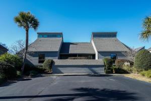 a house with a palm tree and a driveway at 325 Beach Club Villa in Seabrook Island