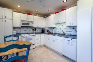 a kitchen with white cabinets and a table and chairs at 325 Beach Club Villa in Seabrook Island