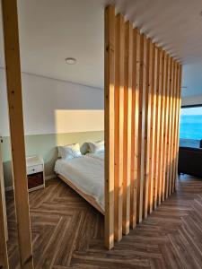 sypialnia z łóżkiem z drewnianymi drzwiami w obiekcie CUSTÓDIO SEA HOME w mieście Praia de Mira