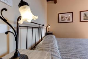 a bedroom with a bed with a lamp on it at Locanda Poggioleone in Castiglione del Lago