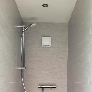 a shower with a shower head in a bathroom at Moher Lodge in Liscannor