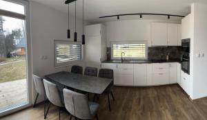 a kitchen and dining room with a table and chairs at Lipno View Jenišov in Jenišov