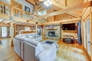 un soggiorno con divani e camino in pietra di Scenic Blue Ridge Cabin Rental with Resort Amenities a Sapphire