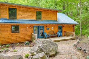 una cabina nel bosco con due sedie e un portico di Scenic Blue Ridge Cabin Rental with Resort Amenities a Sapphire
