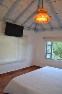 una camera con letto bianco e TV a schermo piatto di Casa Coclín - Paraíso Campestre a Sáchica